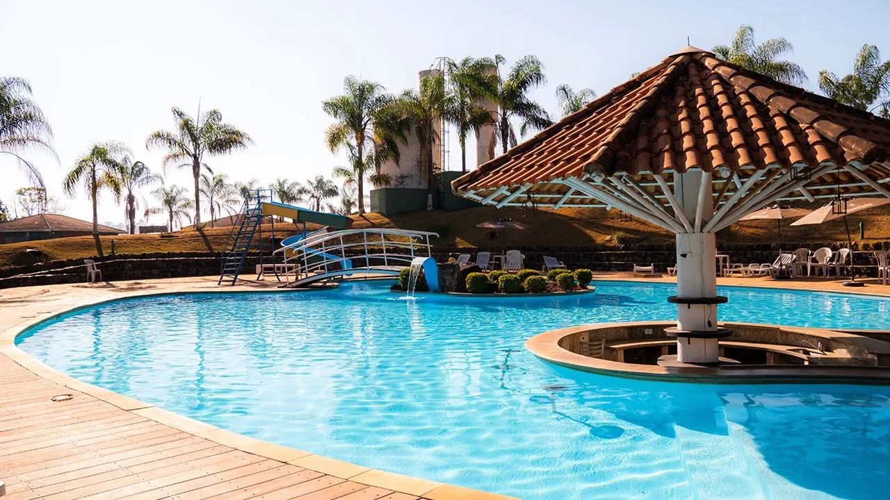 Piscina externa do Hotel Fazenda Poços de Caldas com toboágua e quiosque de telha