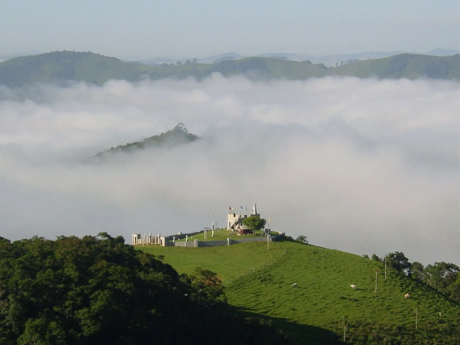 Mirante em formato de castelo no alto de uma colina coberta por neblina na Pousada Fazenda Ribeirão das Flores