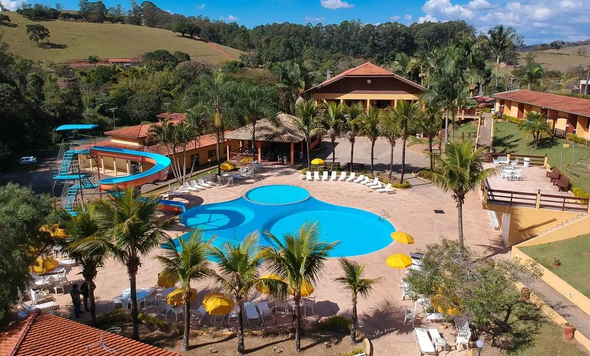 Vista aérea do Hotel Fazenda Saint Nicolas com piscinas, sede e morros de Águas de Lindóia ao fundo
