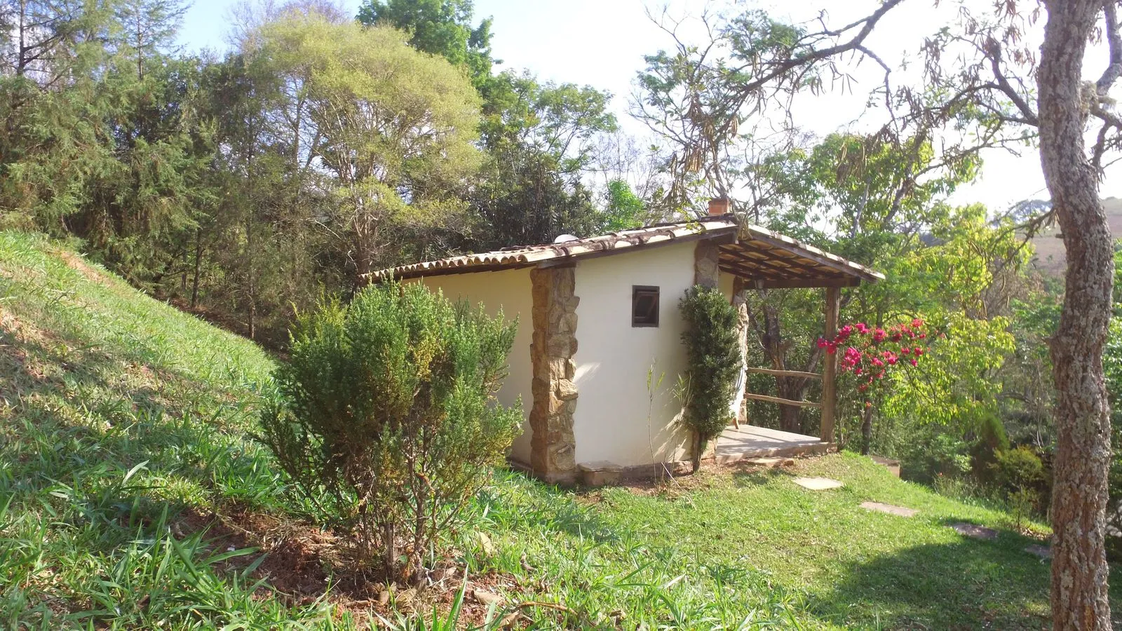 Interior de um chalé com cama de casal, quadros e decoração rústica em madeira