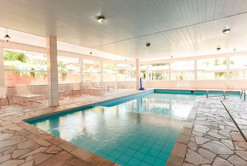 Piscina coberta com espreguiçadeiras do Hotel Fazenda Itáytyba