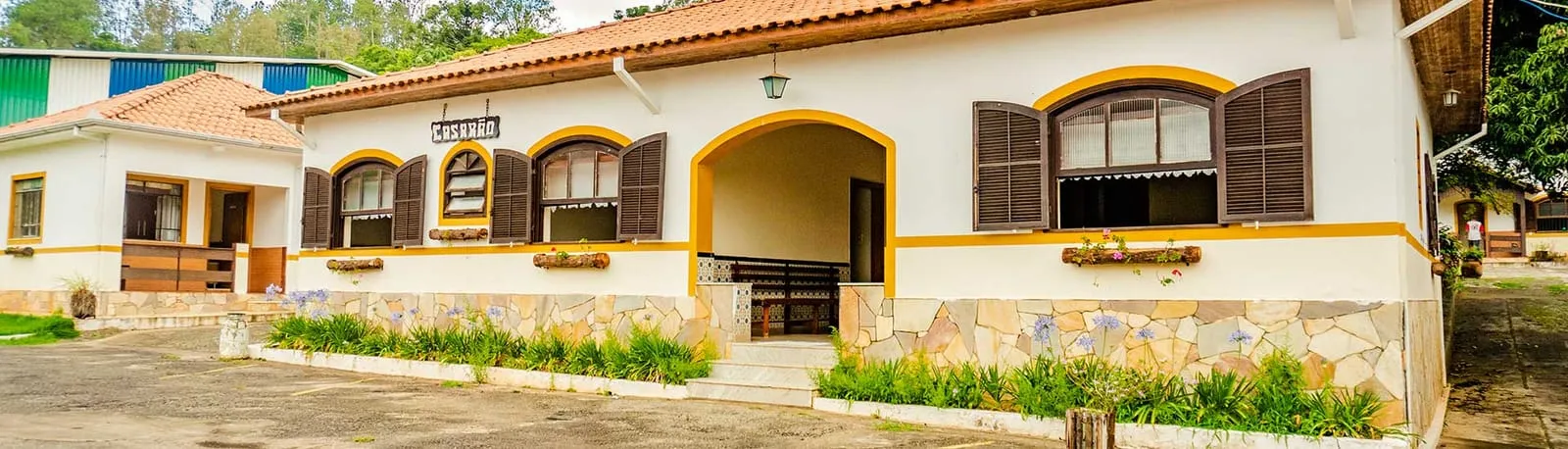 Fachada dos apartamentos do Hotel Fazenda Ramon com janelas de madeira