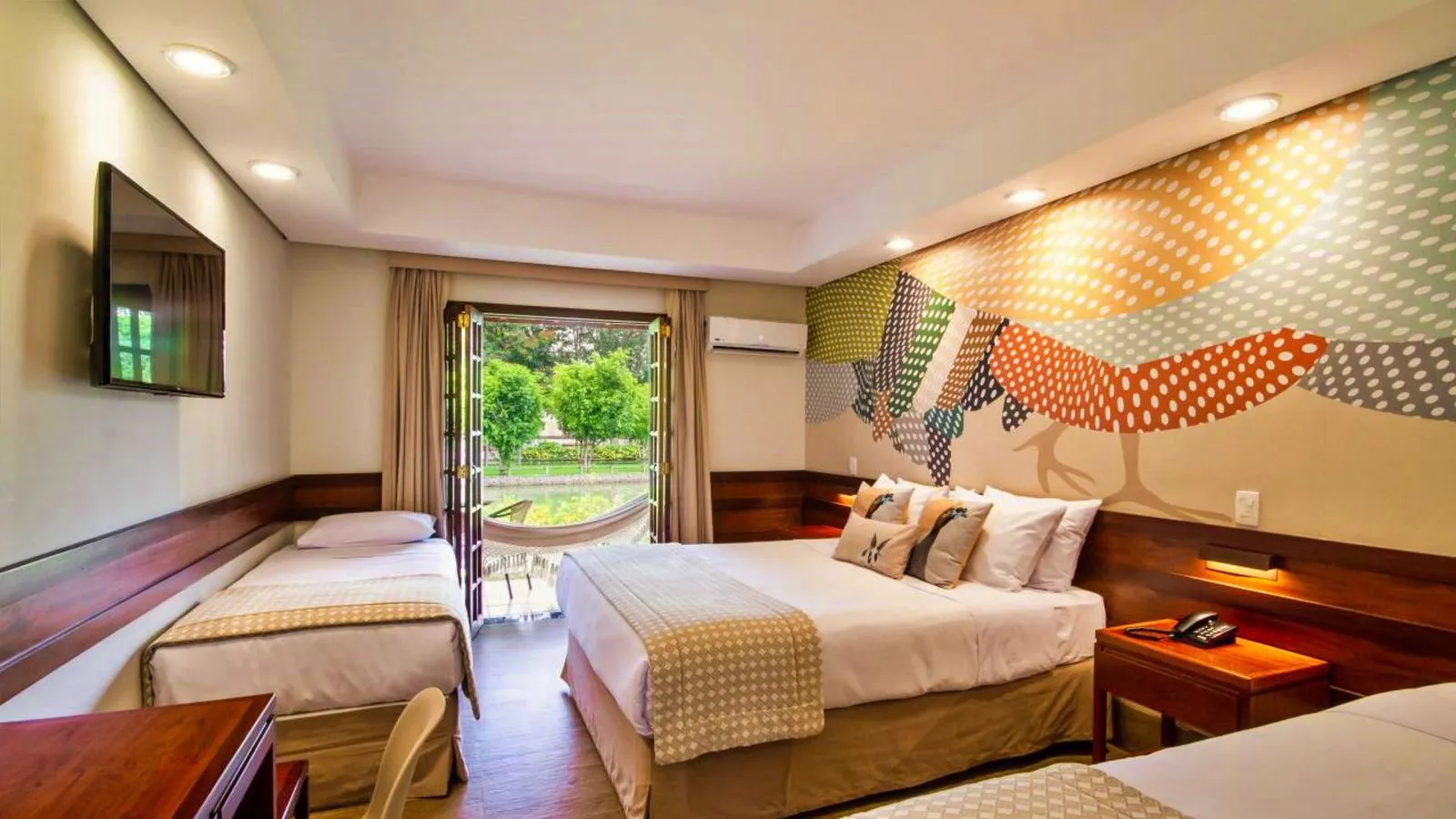 Apartamento familiar com três camas e porta aberta para o jardim com rede
