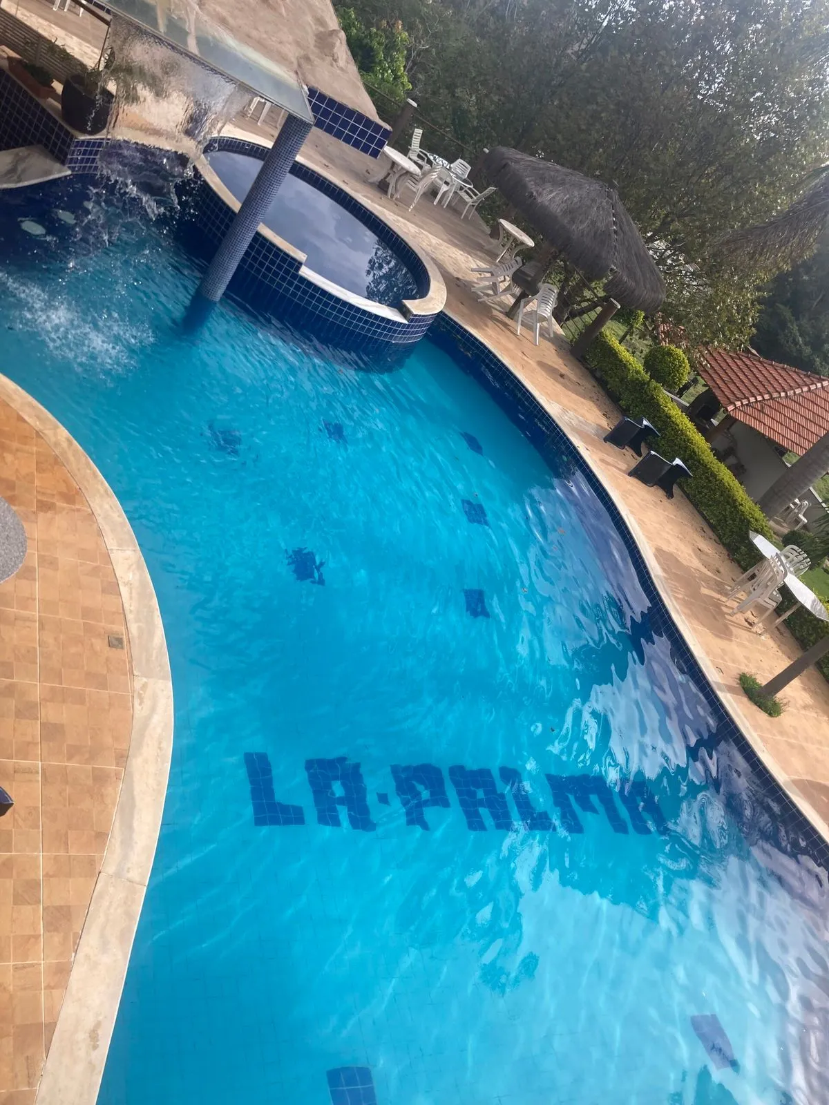 Piscina com o nome La Palma em mosaico no fundo, hidromassagem e cascata ao lado