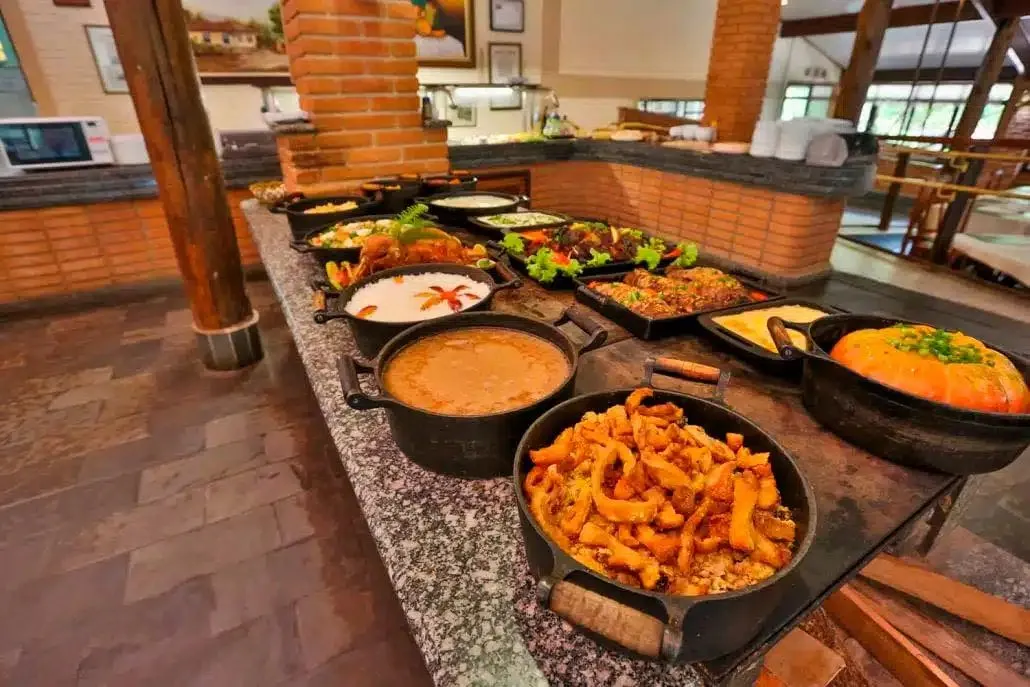 Buffet de almoço em panelas de ferro com comida caseira de fazenda