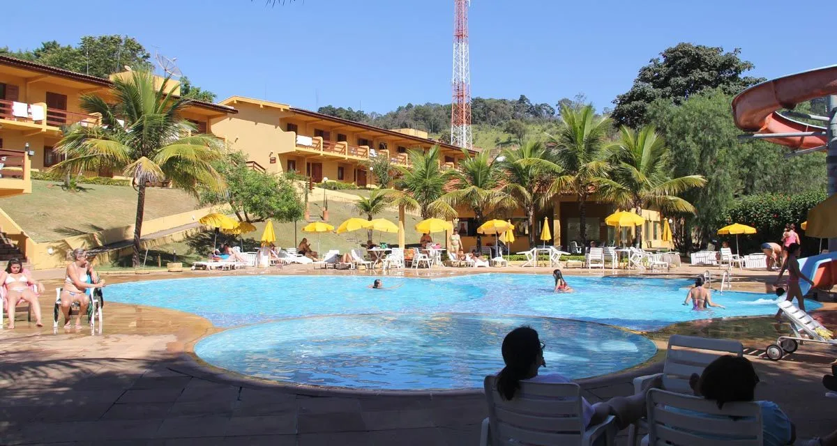 Piscina com hóspedes e blocos de apartamentos do Hotel Fazenda Saint Nicolas