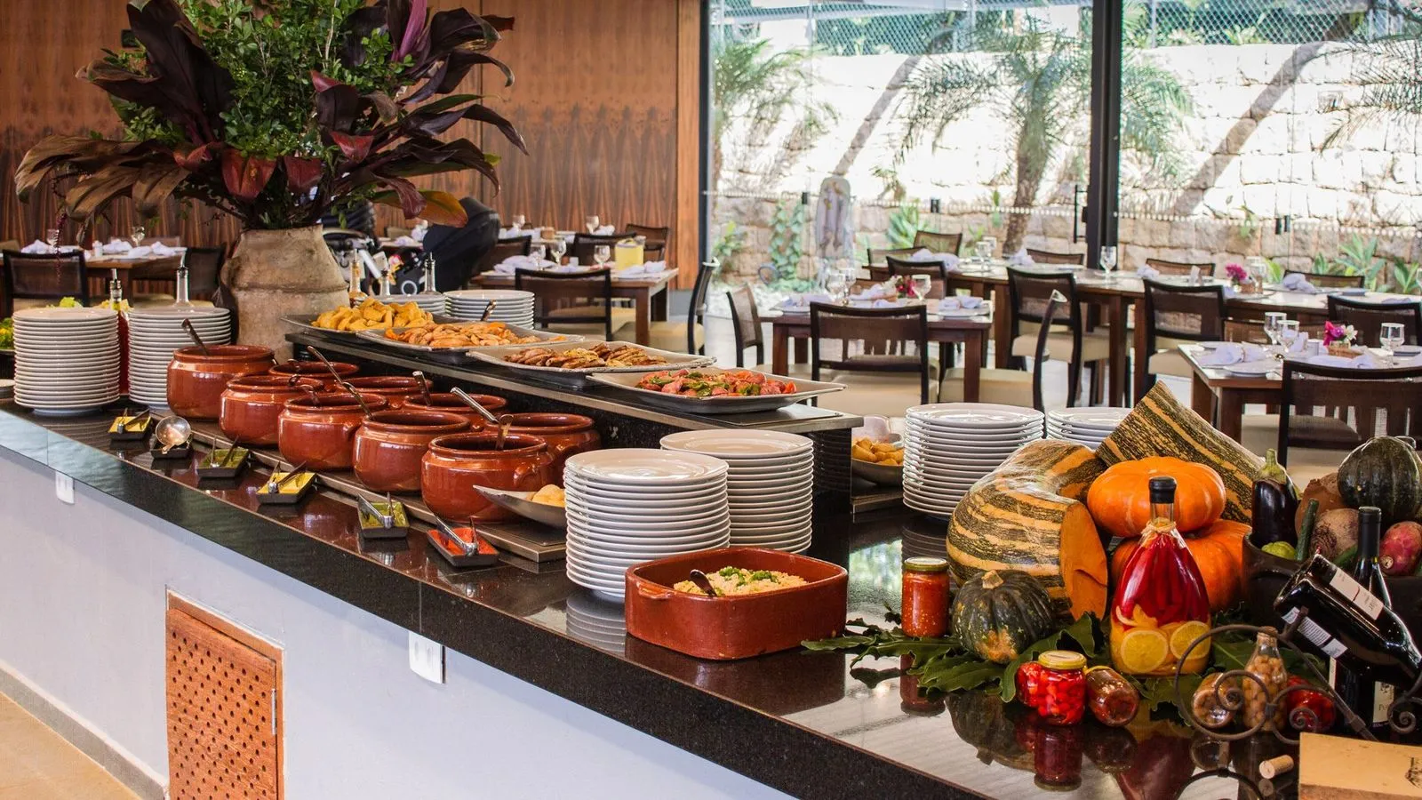 Buffet de comida brasileira com panelas de barro e frios no restaurante da fazenda