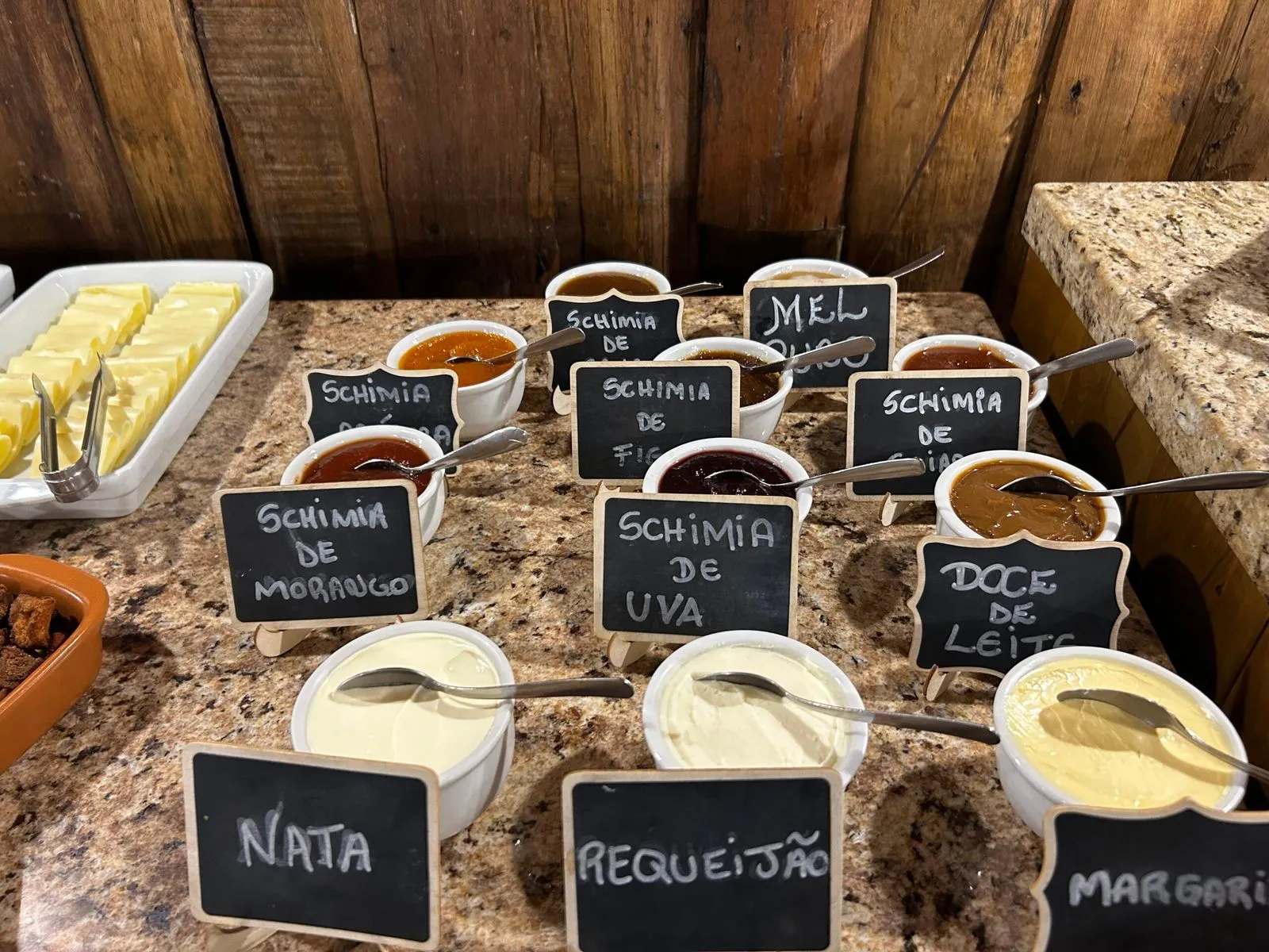 Mesa de café colonial com potes de geleias e doces caseiros identificados no Fazenda Hotel Invernadinha