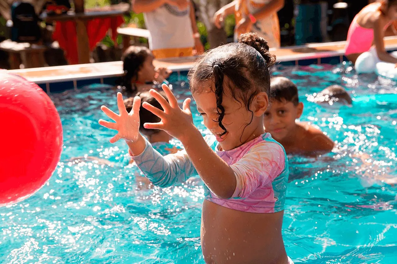Crianças brincando com bola inflável na piscina do Sítio Green Valley