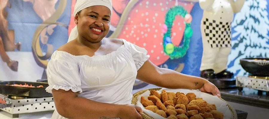 Cozinheira servindo doces típicos da gastronomia do Fazzenda Park Resort
