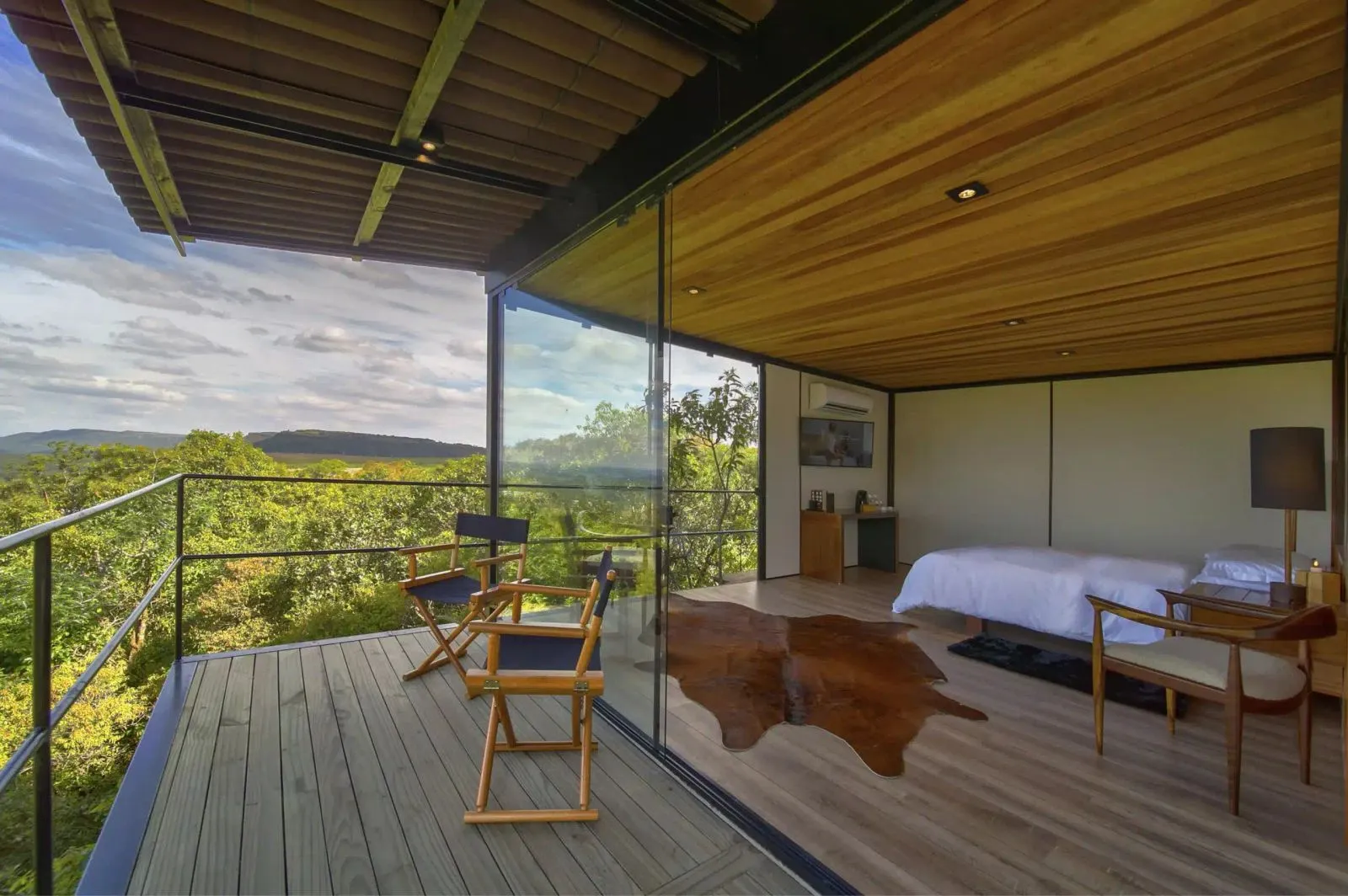 Chalé com deck e cadeiras na varanda voltada para a paisagem no Hotel Fazenda Cainã
