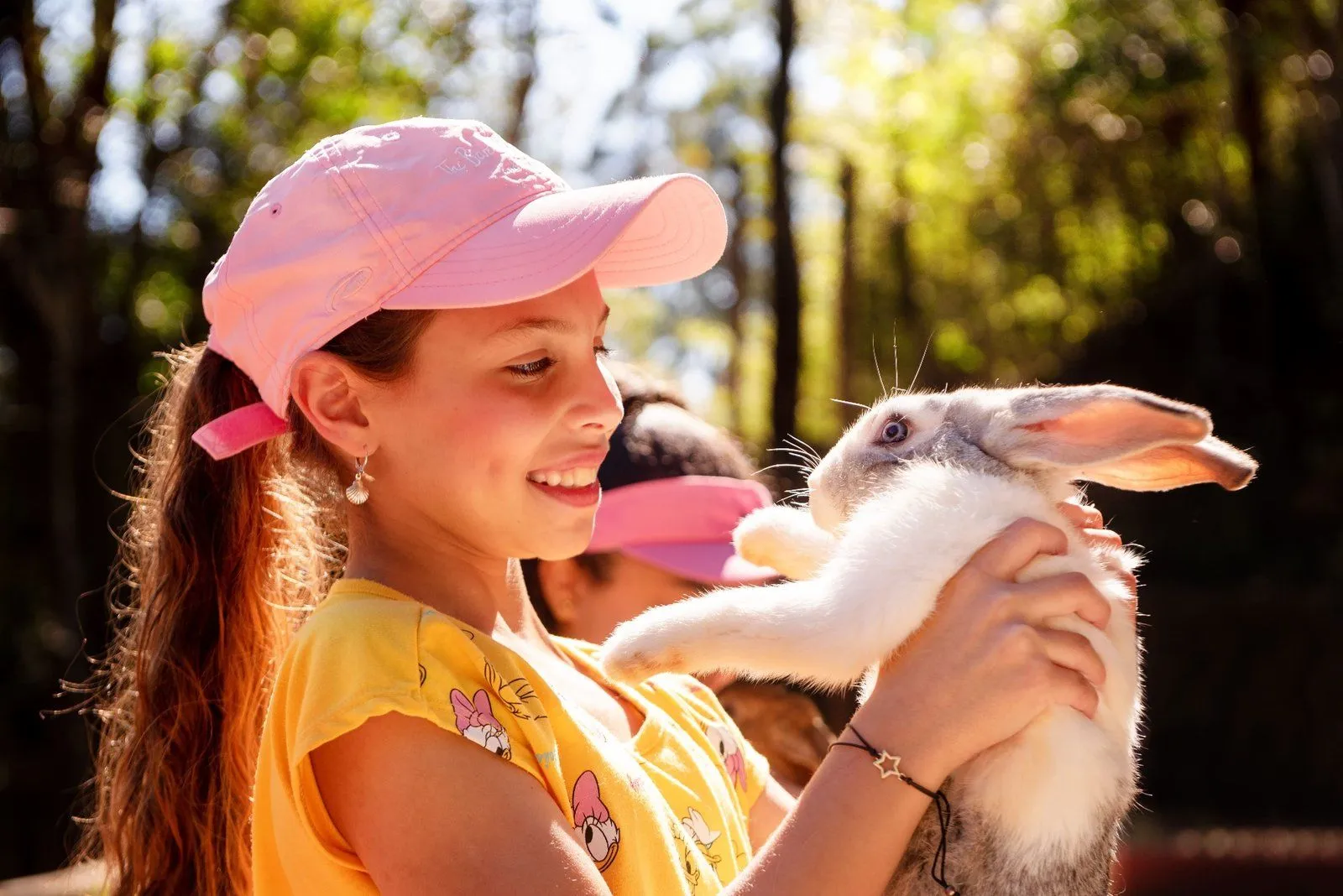 Criança em contato com coelho na mini fazenda do Hotel Vila Verde